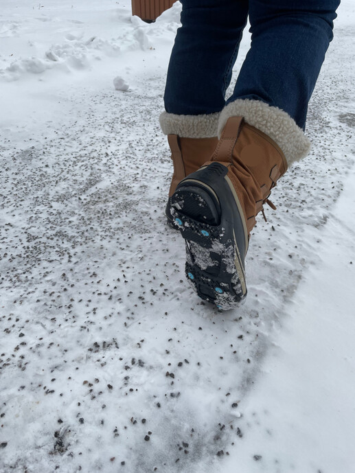 Broddar på skor gående utomhus i snö